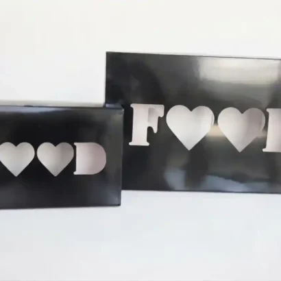 Black catering boxes with "FOOD" heart cut-out window